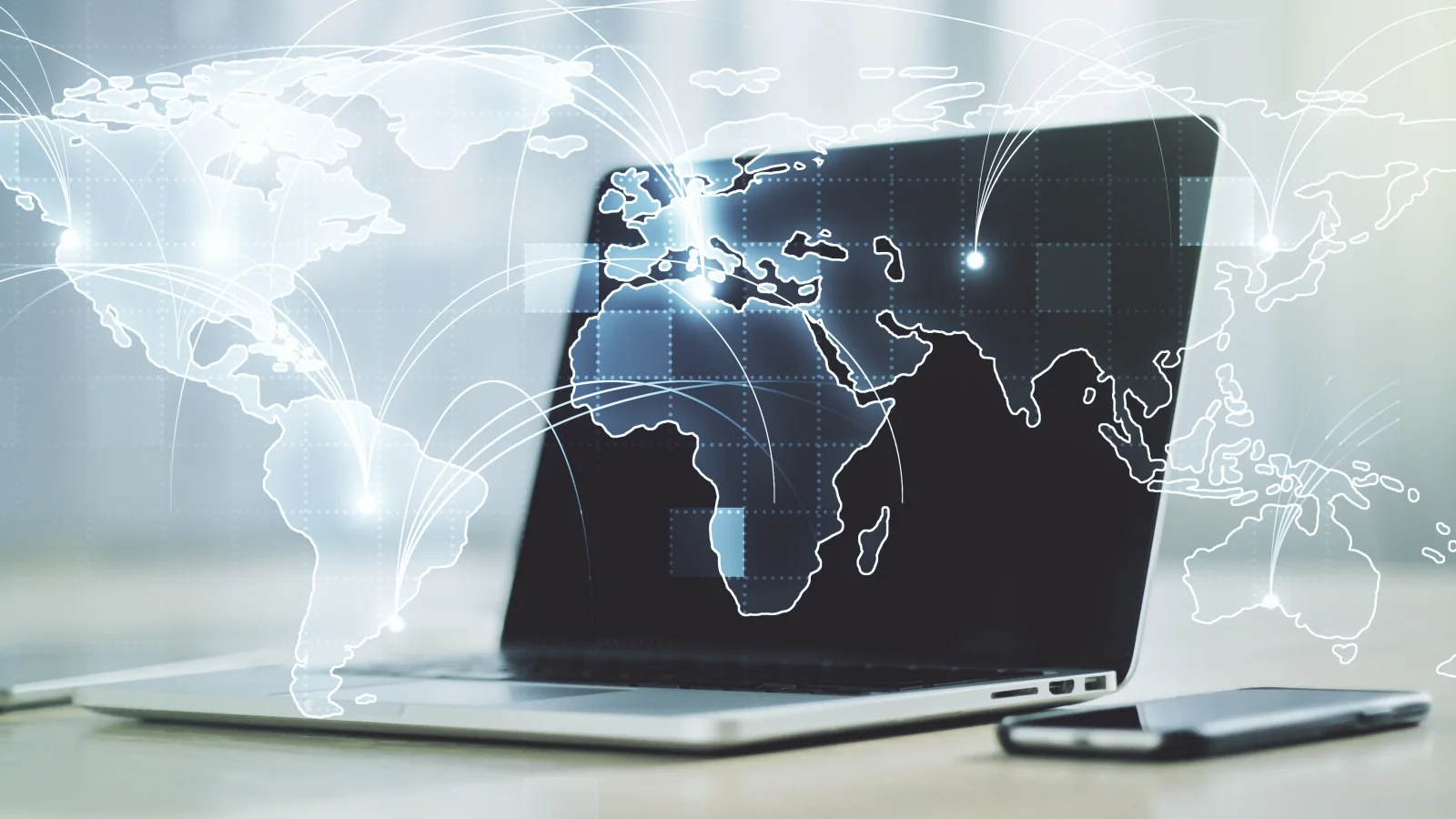 Laptop displaying holographic world map with global connection arcs representing international mass payout transfers