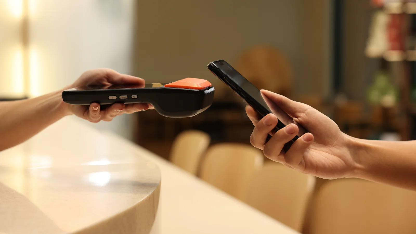 Customer paying with a smartphone at a payment terminal.